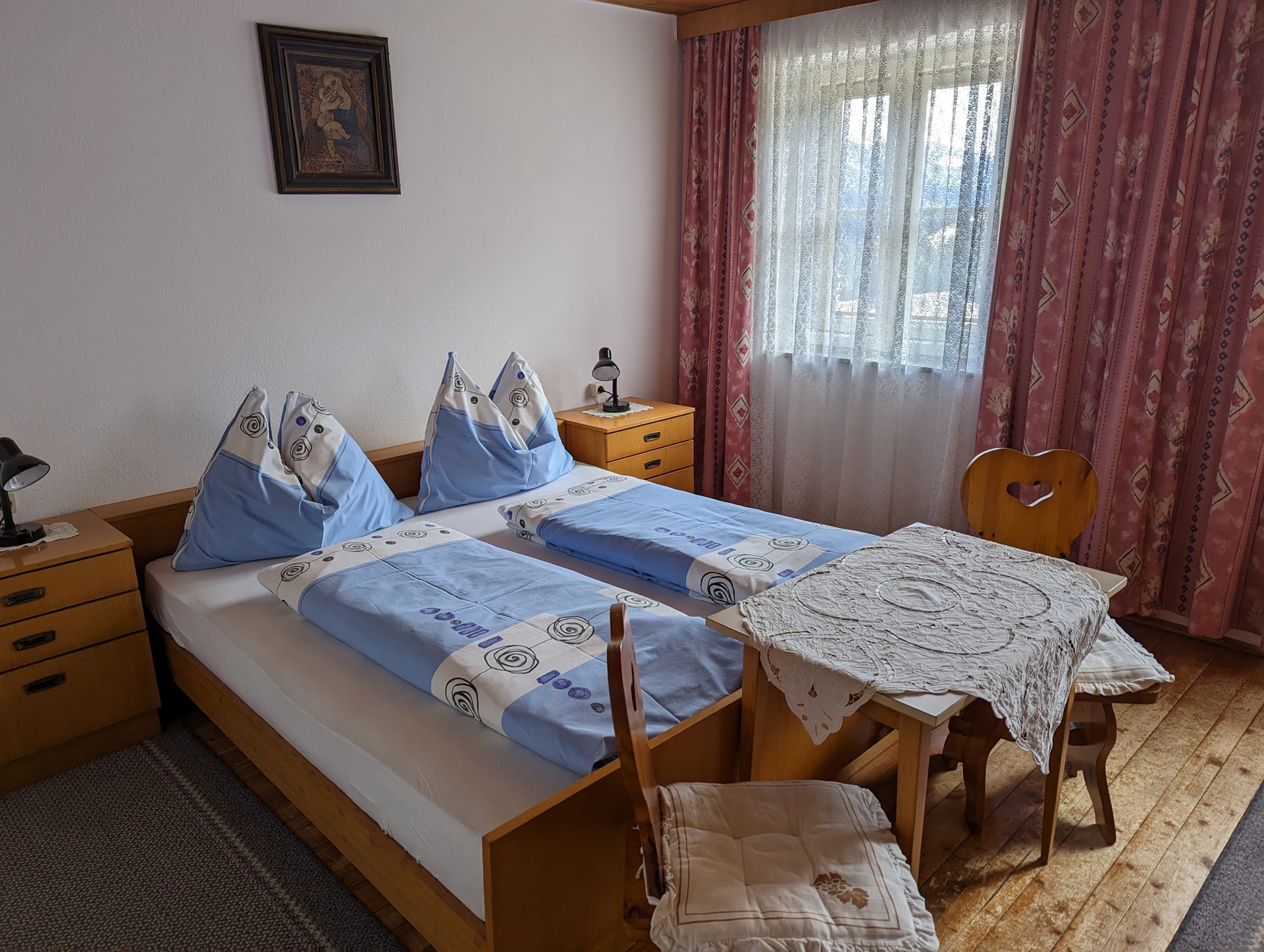 Helles Doppelzimmer mit blauer Bettwäsche